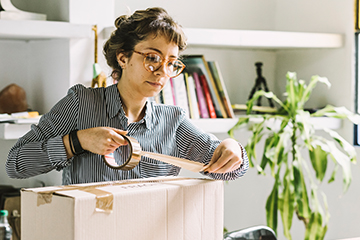 Young woman packing a box 360x240